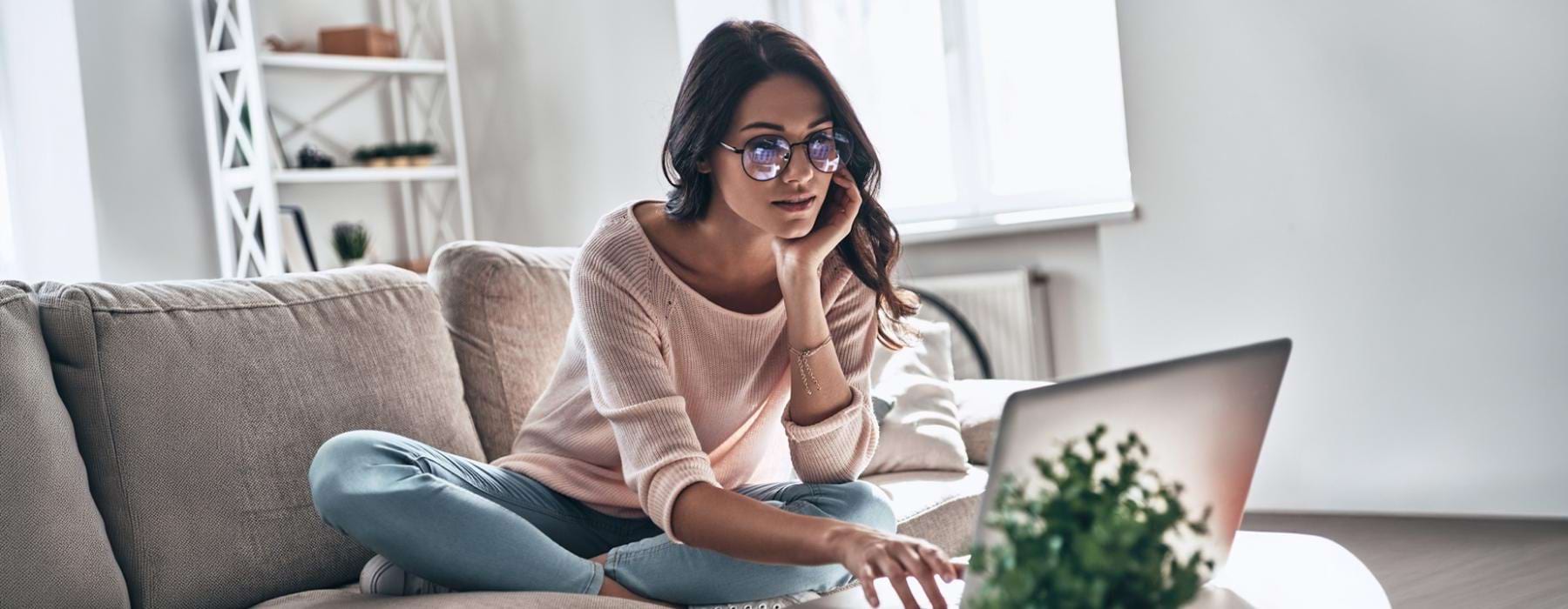 a woman sitting on a couch using a laptop